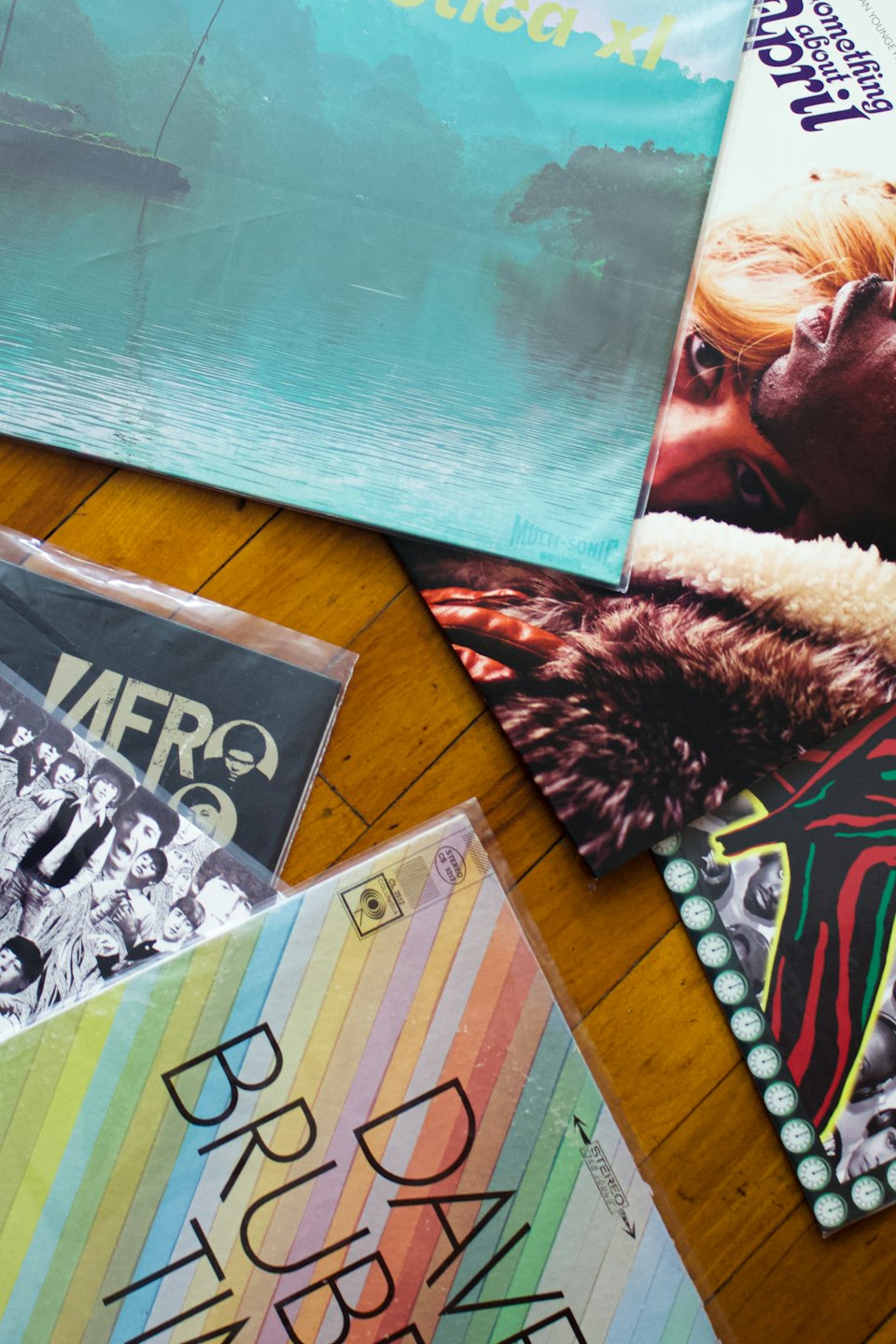 Gamla vinylskivor utspridda på ett trägolv.